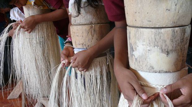 Alumnos tejiendo sombreros finos de paja toquilla.